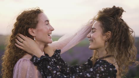 Two-beautiful-curly-girls-combing-together-their-hair-outdoors