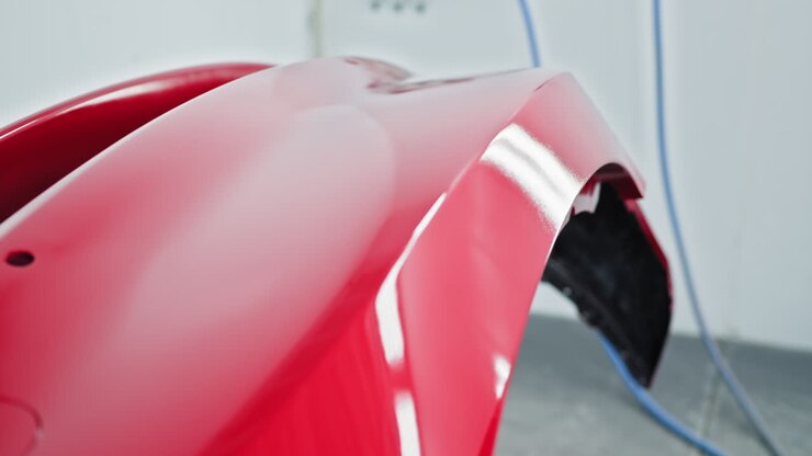 lavoro di verniciatura rosso del paraurti dell'auto