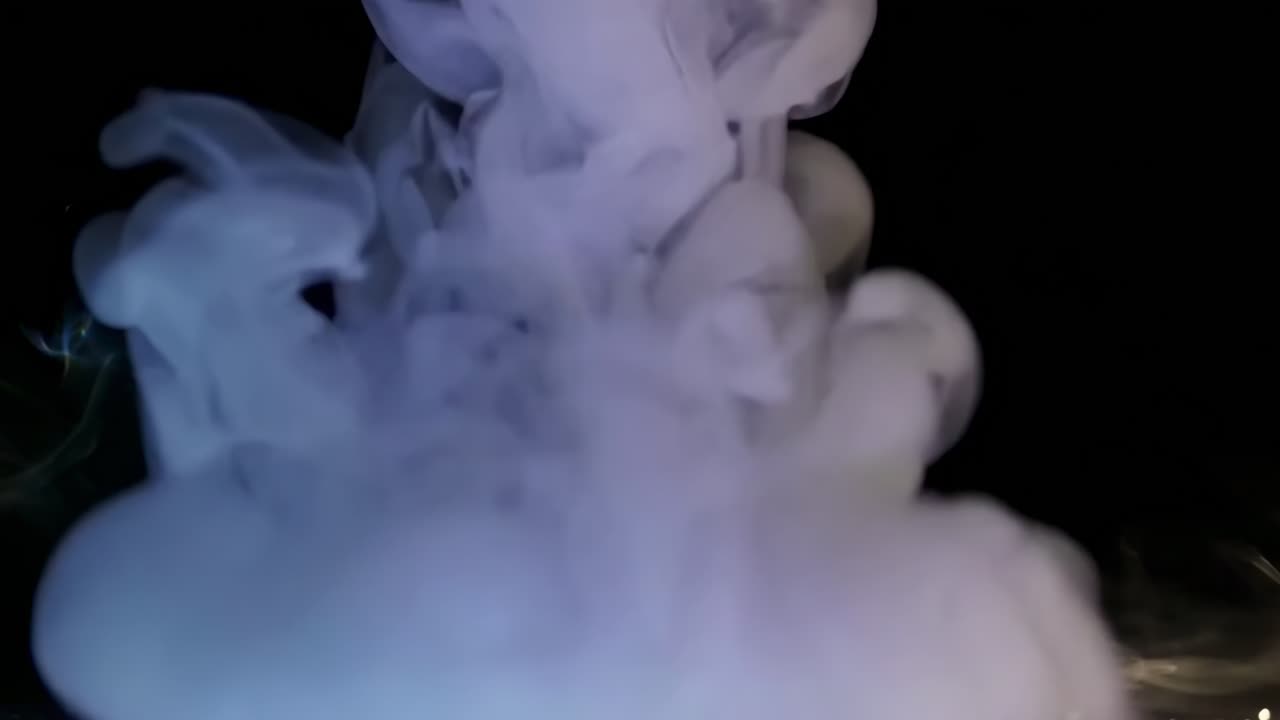 Etereo fumo che turbina in un video con angolazione bassa, ambientato su uno sfondo scuro, creando un'atmosfera mistica