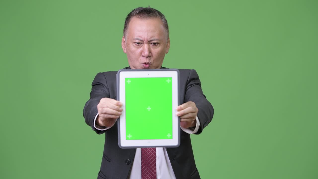 디지털 태블릿을 보여주는 성숙한 일본 사업가
