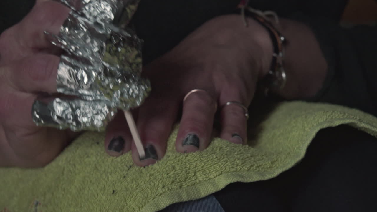 feche a filmagem de uma mulher caucasiana fazendo manicure dentro de casa