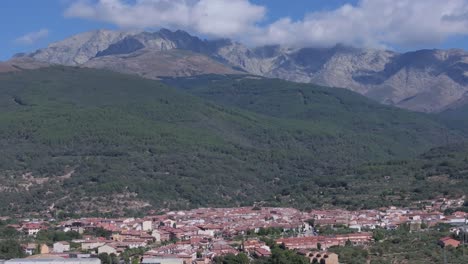 70mm drone filming of the town of candeleda in ávila with its majestic background of mountains where the clouds appear hooked, a parallax effect is created by the movement