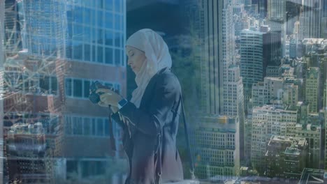 Animation-of-asian-woman-in-hijab-with-camera-over-cityscape