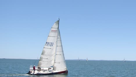 A-monohulled-sailing-boat-under-full-sail-leans-into-the-wind-in-Morten-Bay