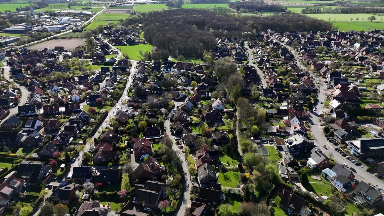 Small american city suburb during sunny day in spring. Housing area with forest in Background. Farm fields in peaceful area of USA. Aerial forward wide shot. Two-story homes in village.