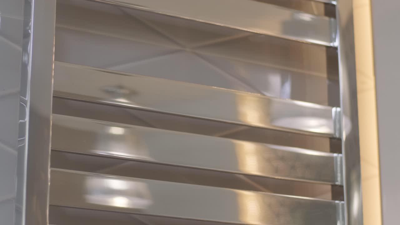 여자의 손은 화장실에서 가열 된 수건 레일, 건조기에서  수건을 제거합니다.