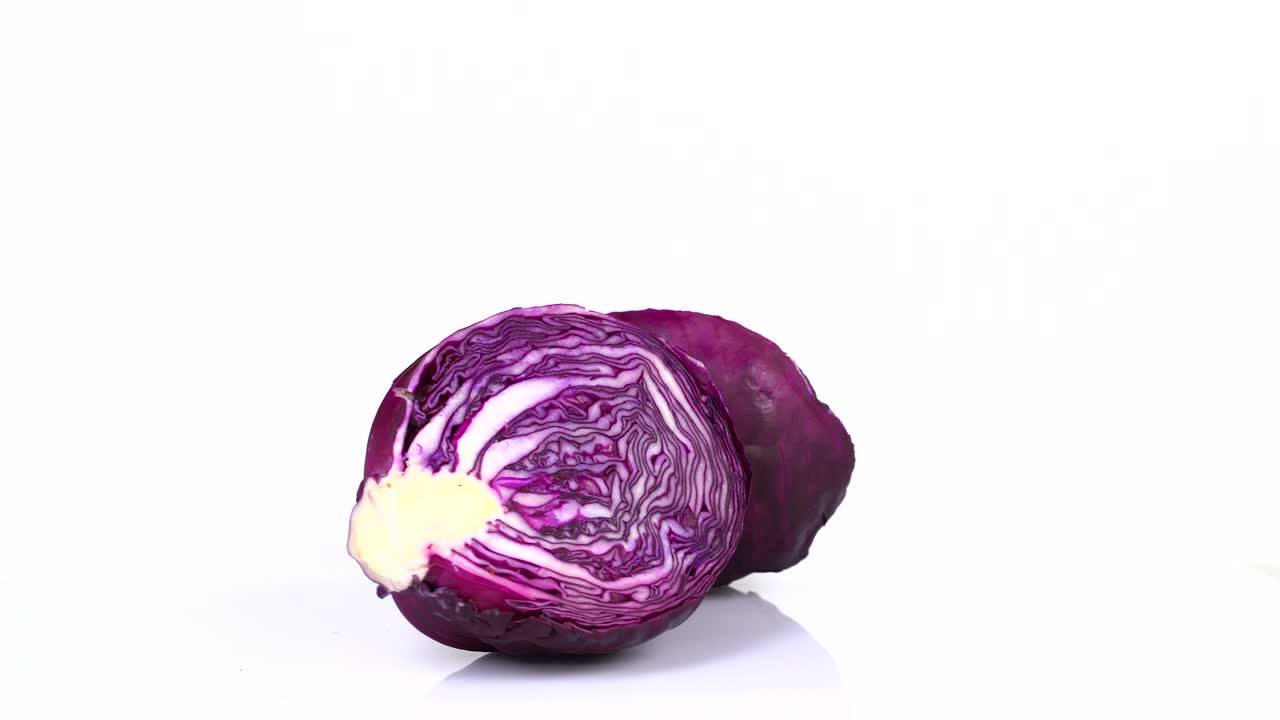 un bucle interminable de un repollo rojo fresco girando sobre un fondo blanco. vista lateral.