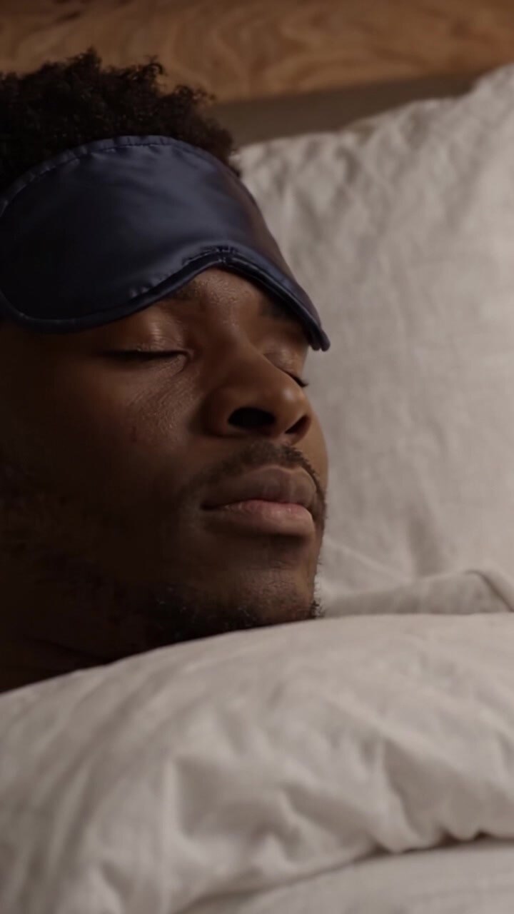 A Peaceful Moment: The Tranquility of Resting in Bed with a Sleep Mask Over Eyes During a Calm Night Amidst Comfortable Bedding and Soft Pillows
