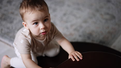 lovely toddler boy playing on the stairs indoors. little kid at home. view from top.