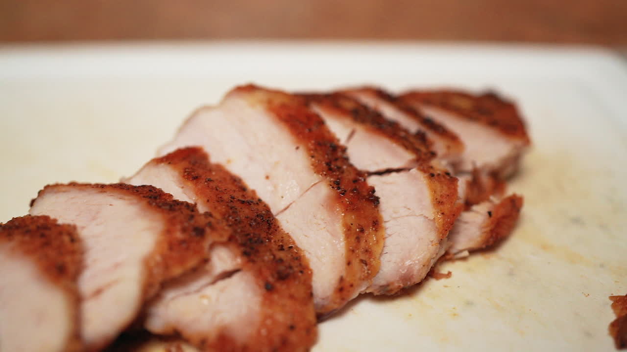 커팅 보드에 얇게 썬, 구운, 뼈 없는, 껍질 없는 닭 가슴살 - 느린 풀백 매크로 보기