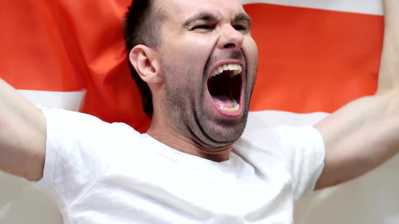 Angielski kibic świętujący, trzymający flagę Anglii w zwolnionym tempie, 4K, wysoka jakość.