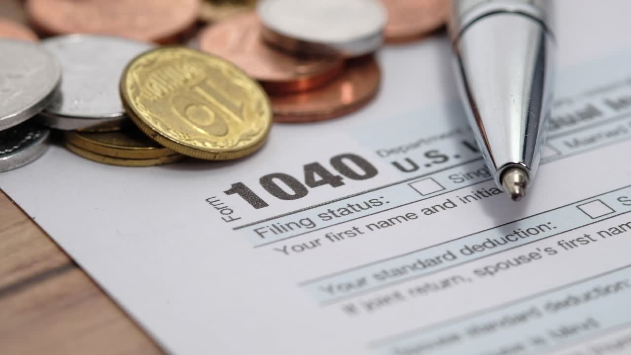 formulario de impuestos 1040 con monedas y bolígrafo