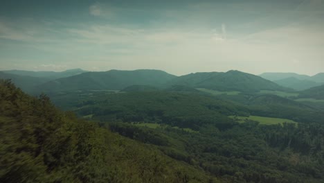 Epic-drone-shot-flying-over-a-hill,-overlooking-a-valley,-spectacular-view-in-the-middle-of-the-day,-beautiful-nature,-summer