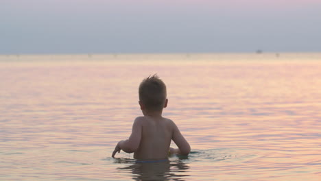 Junge-Spielt-Mit-Spielzeugboot-Im-Meer