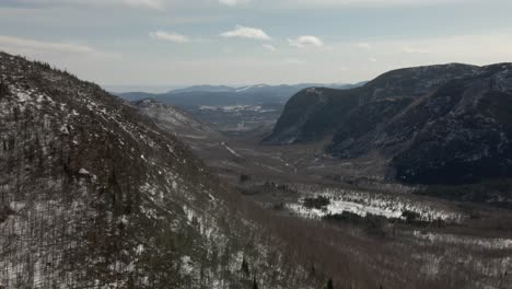 Massive-Forested-Hills-With-Frosted-River-Under-Gloomy-Sky-In-Mont-du-Dome,-Quebec,-Canada