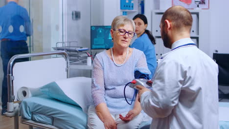 el médico mide la presión arterial de una mujer jubilada de edad avanzada
