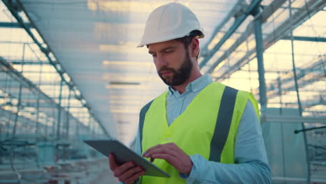 Trabajador-De-Fábrica-Con-Tableta-Inspeccionando-Nueva-Fabricación-Con-Uniforme-Verde