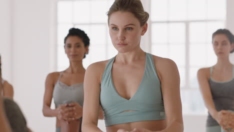 beautiful yoga woman practicing prayer pose in fitness studio caucasian female training with instructor group of women enjoying healthy balanced lifestyle