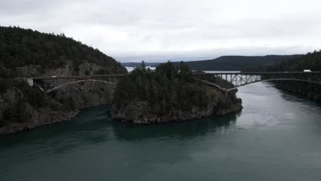 Traffic-flowing-across-the-Deception-Pass-bridge,-Washington,-aerial-track