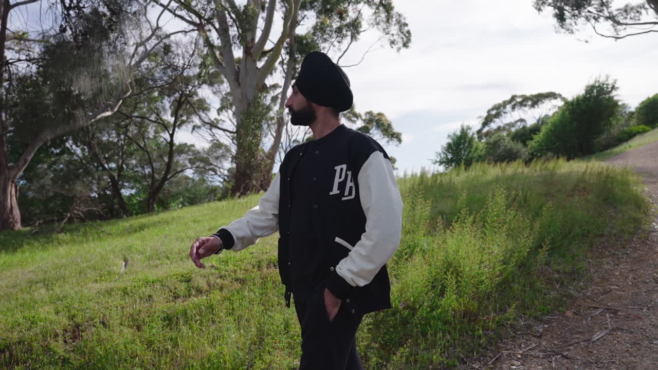 Indian Sikh Man Walking Downhill In Summer Nature - medium shot