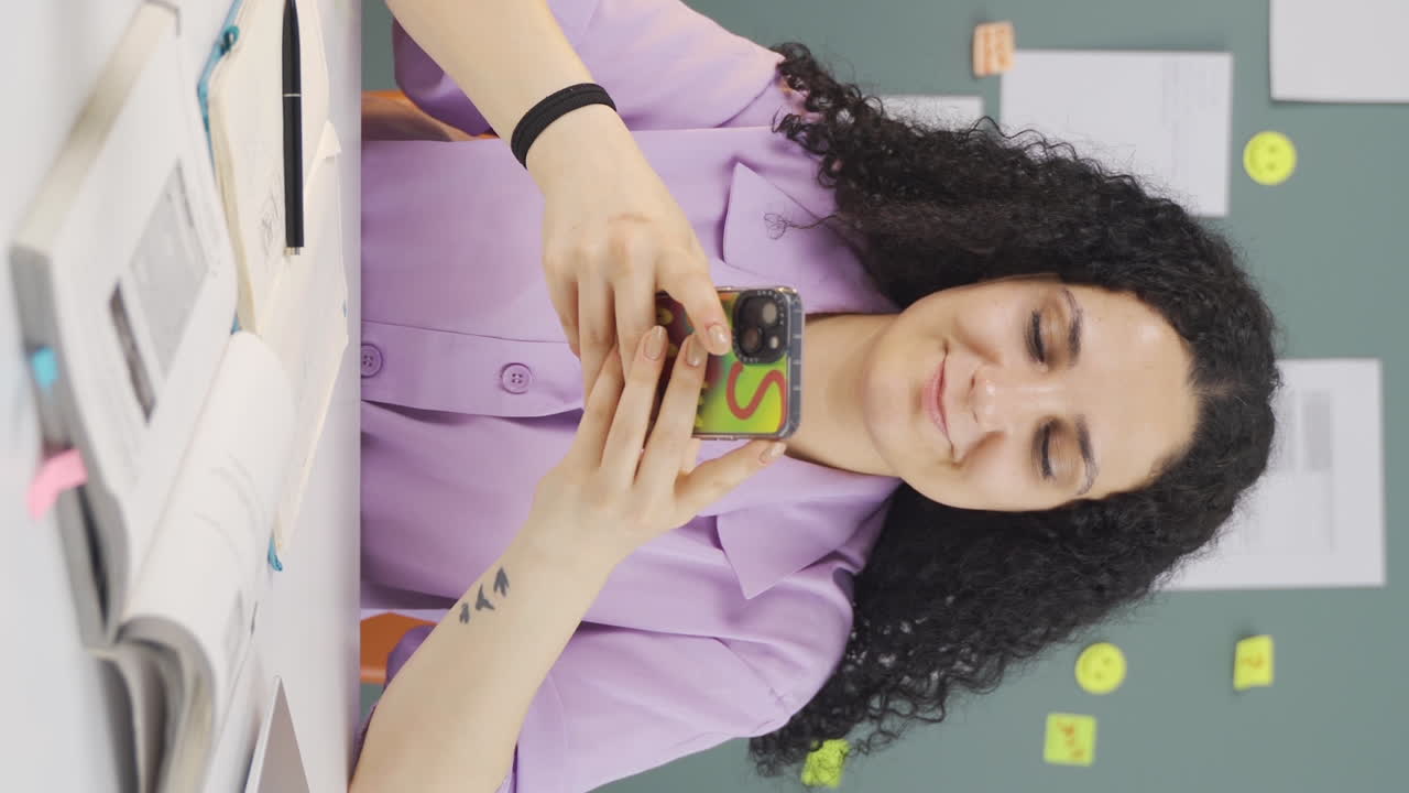 vídeo vertical de una estudiante chateando por teléfono.