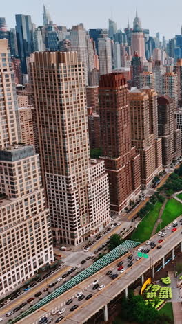 drone footage over waterfront of new york. manhattan view with busy traffic on the roads. aerial perspective. vertical video