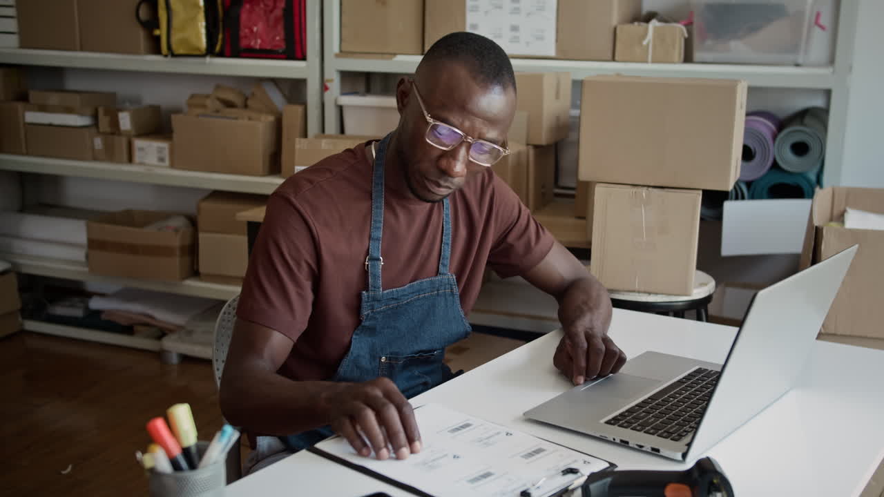 Logistics Specialist Working at Desk in Storage Office