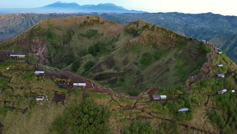 cafes-along-the-crater-rim-and-ridge-of-Mount-Batur-volcano-in-Bali-Indonesia-during-sunrise,-aerial