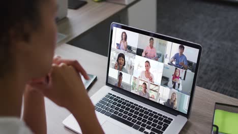 African-american-woman-having-a-video-conference-on-laptop-with-office-colleagues-at-office