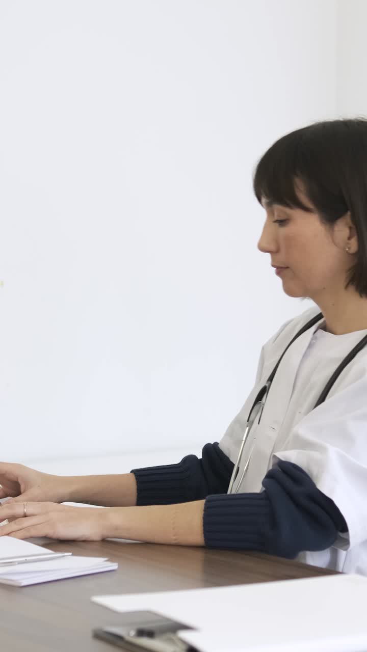 Female doctor sitting on chair at computer desk to start her work