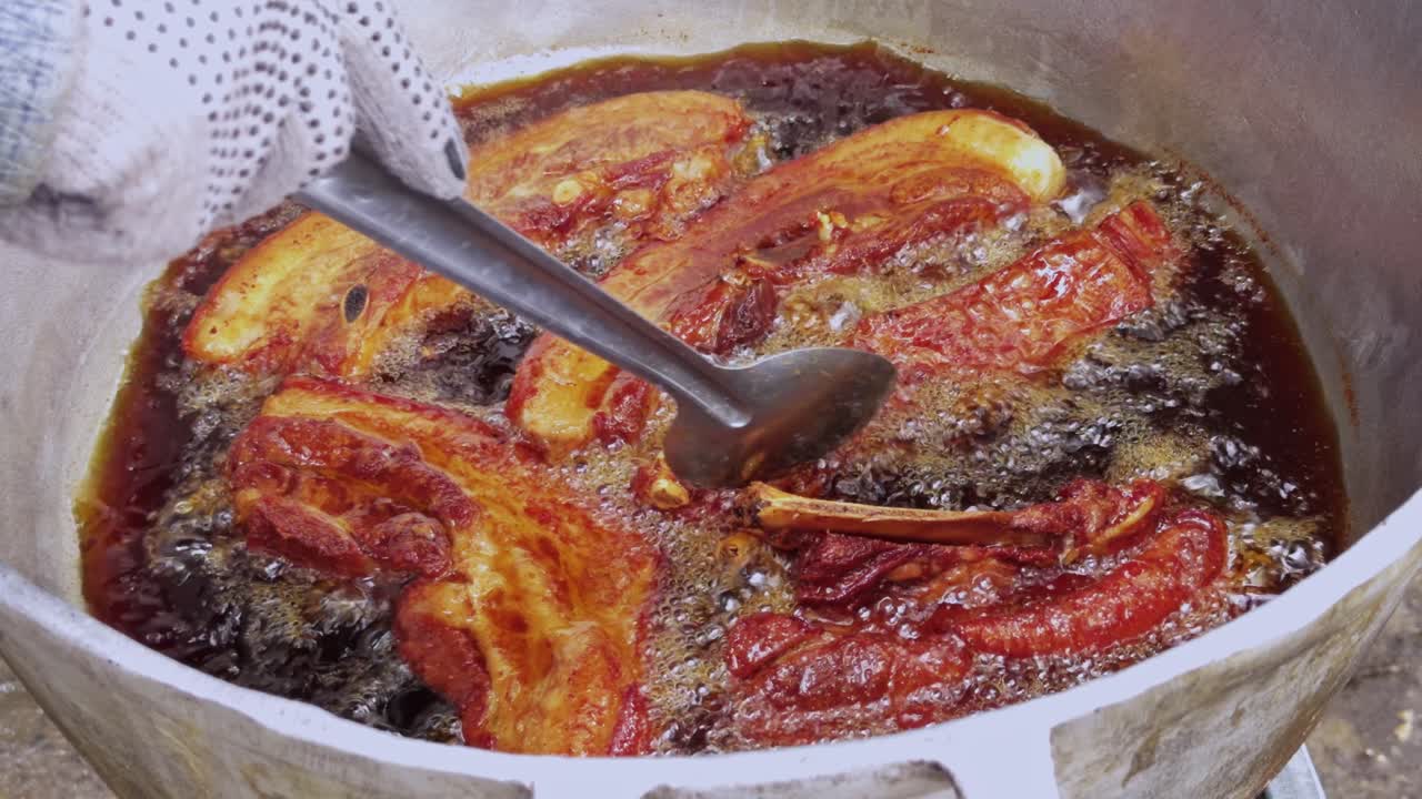 Preparazione tradizionale di ciccioli fritti a Santiago, Repubblica Dominicana