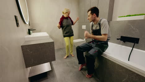 happy couple dancing in a modern bathroom