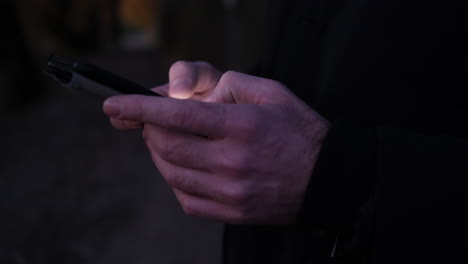 Nahaufnahme-Der-Hände-Des-Mannes,-Die-Nachts-Auf-Dem-Smartphone-Tippen