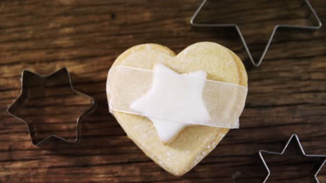 cookie cutter and cookie on wooden plank 4k