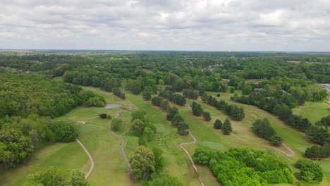 flying over a beautiful green golf course with  storm clouds rolling in