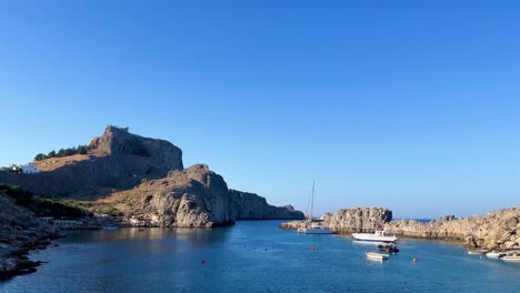 Playa-De-Lindos-Con-Vista-Al-Castillo-De-Las-Ruinas-De-La-Acrópolis-En-Rodas,-Grecia,-Destino-De-Viaje-Filmado-En-4k-Durante-El-Día