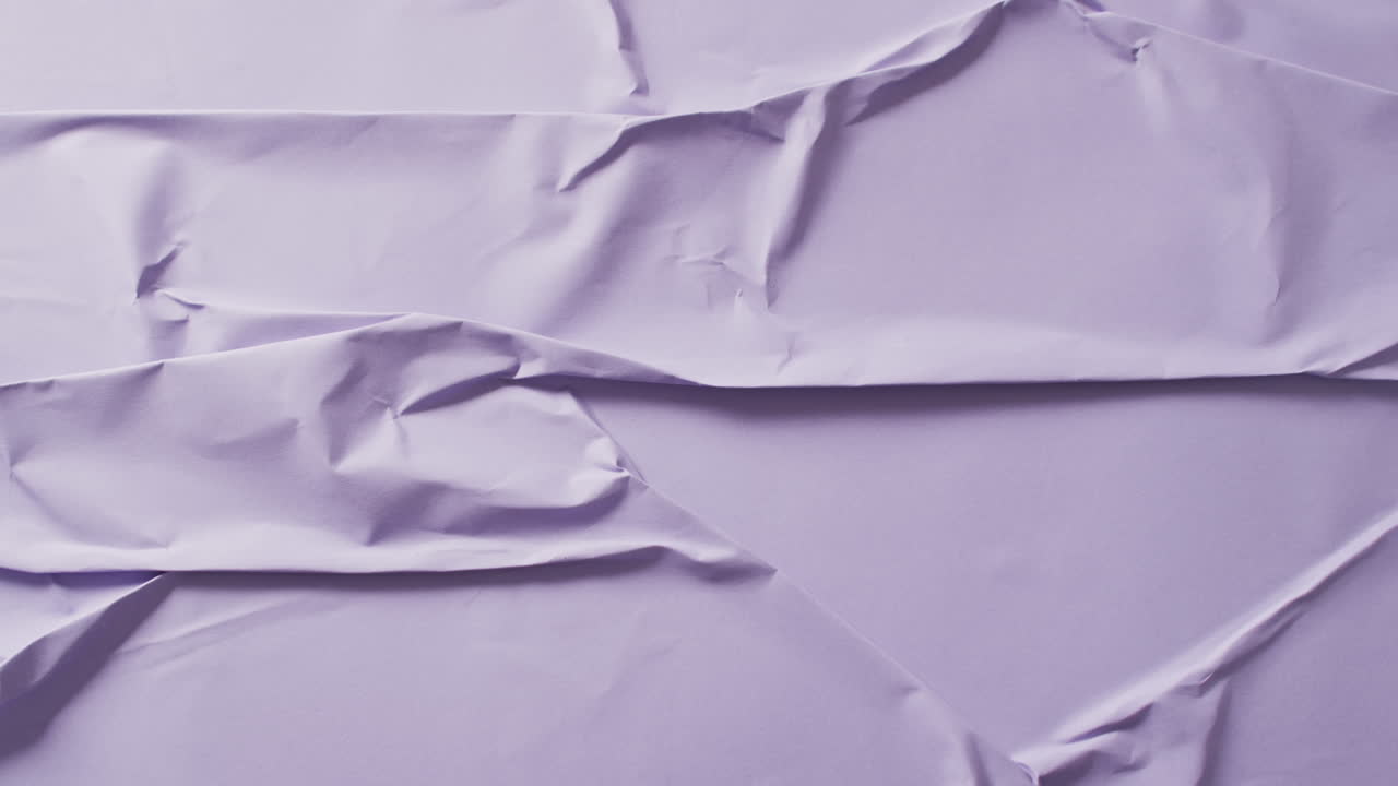 Video of close up of violet creased fabric with copy space