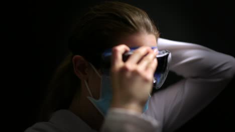 Coronavirus-Scientist-Doctor-wearing-a-mask-applies-safety-goggles-and-looks-into-camera