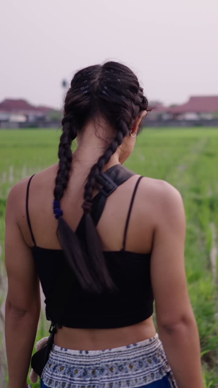 Woman with braids in rice paddy