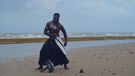 a muscular, dark-skinned man, a brilliant nekharis in cosplay, stands on a tropical beach