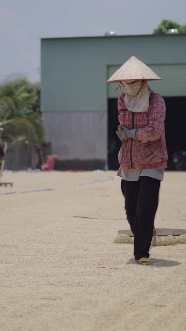A person wearing an Asian conical hat in a field