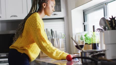 African-american-woman-cleaning-kitchen-after-cooking