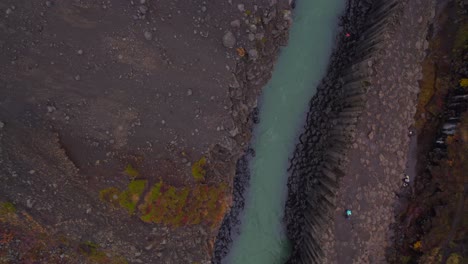 People-walking-Studlagil-canyon-with-aerial-top-down-perspective