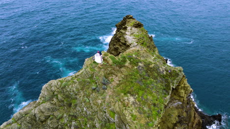 aerial orbit around porto moniz lighthouse atop craggy ilheu mole island