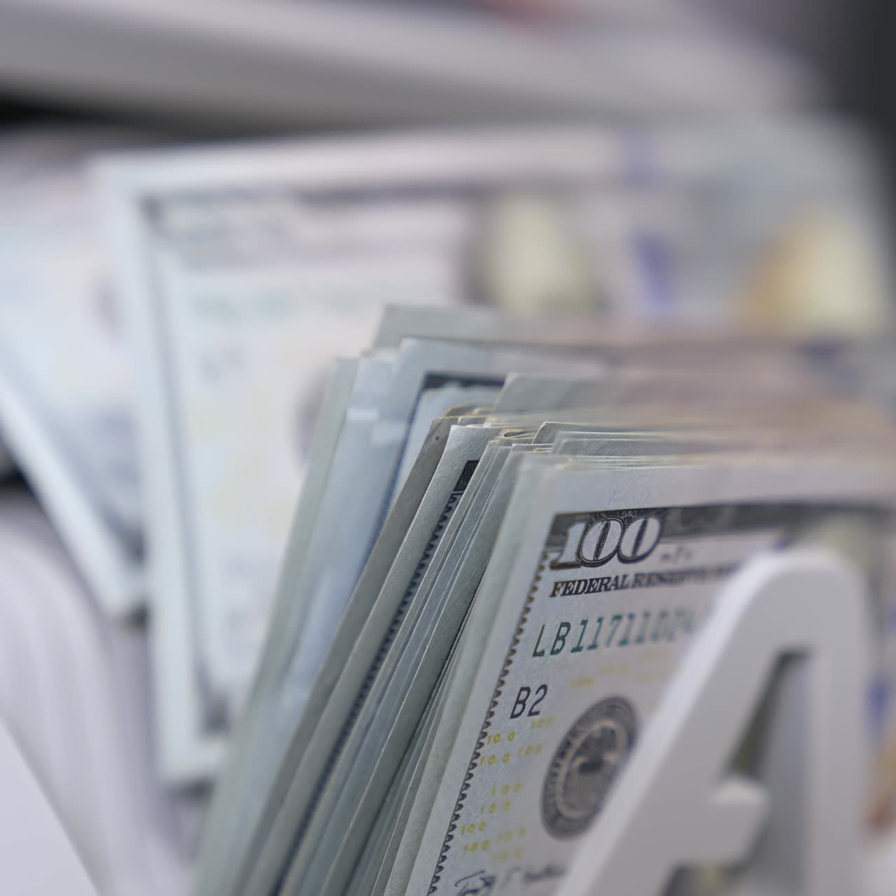 Money counting machine. Banknote counter are counting hundred dollar bills. Close-up