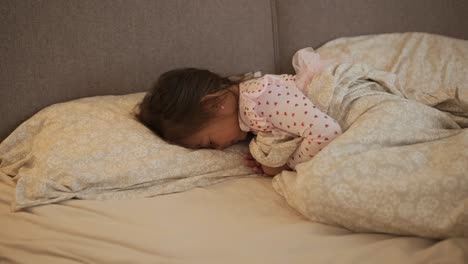 little girl sleeping peacefully in bed