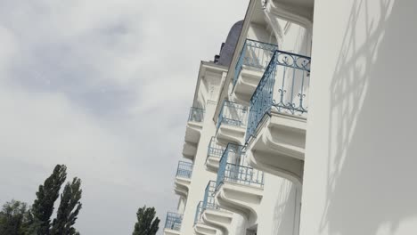 elegant white building with blue balconies