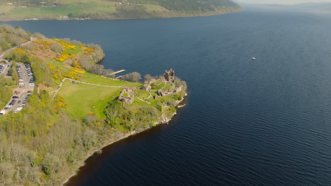Aerial drone footage of Urquhart Castle on the shores of Loch Ness, Scotland. Sweeping views of the historic ruins, the famous loch, and the surrounding dramatic Highland landscape