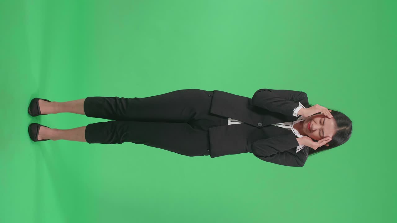 Full Body Of An Asian Business Woman Having Headache While Standing In Front Of Green Screen