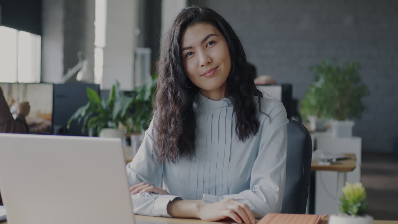 Mujer trabajando en una computadora portátil en una oficina moderna